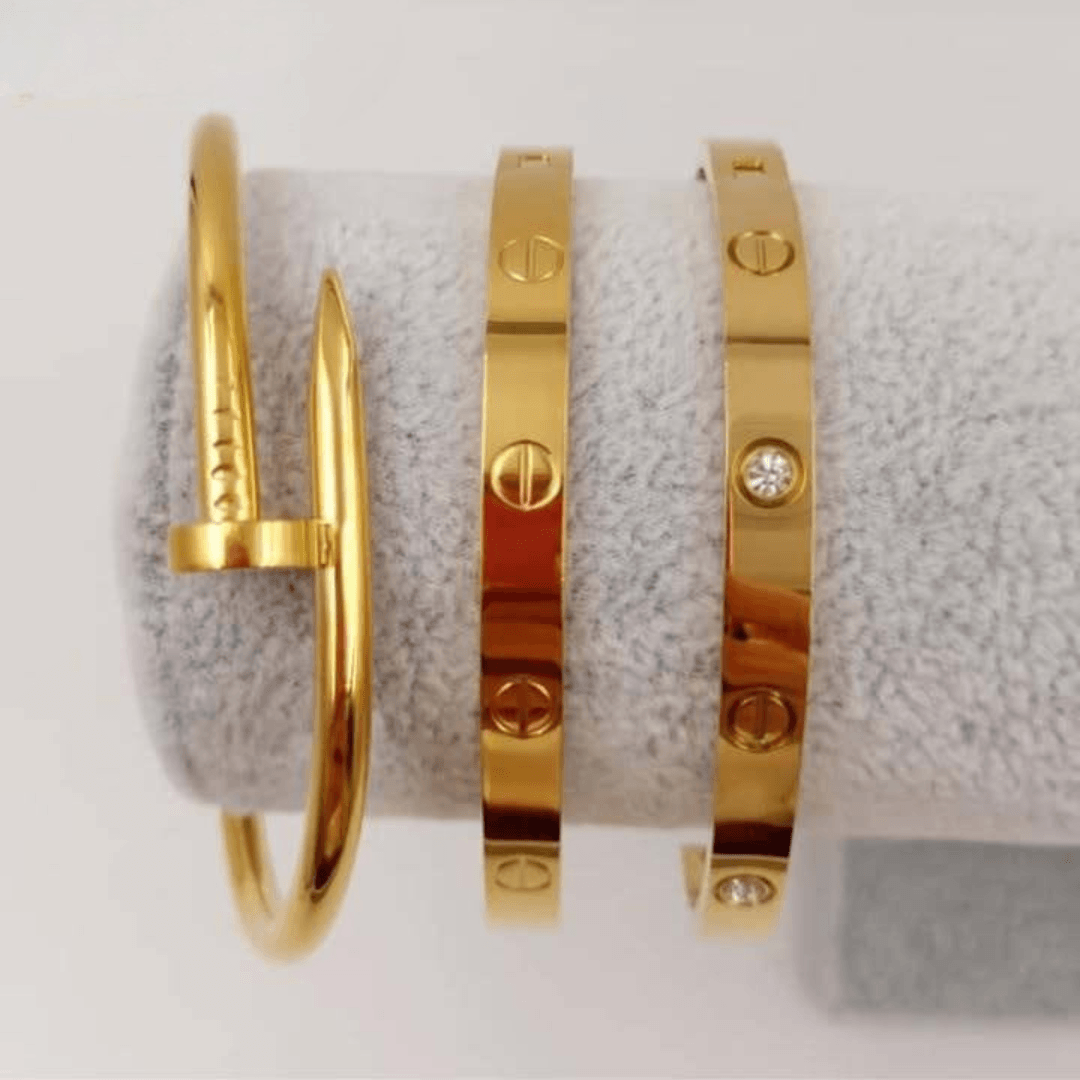 first class jewelry set featuring three stunning gold bangles on a display.