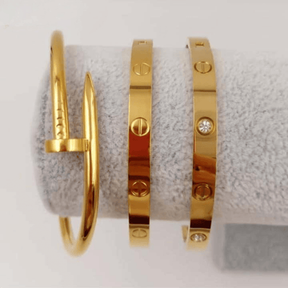 first class jewelry set featuring three stunning gold bangles on a display.
