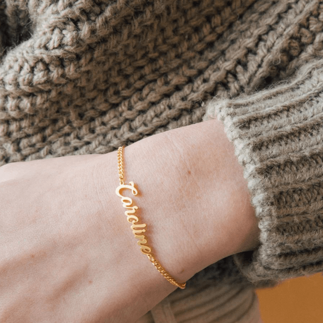 Personalized Name Bracelet Custom Script Jewelry worn on a wrist with the name Caroline in elegant gold lettering.