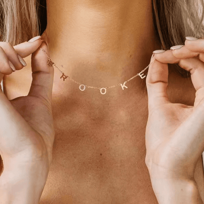 Personalized Name Necklace From Separate Letters showcasing elegant gold letters on a delicate chain worn around the neck.
