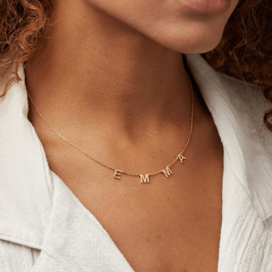 Personalized Name Necklace From Separate Letters showcasing elegant gold letters on a delicate chain worn around the neck.