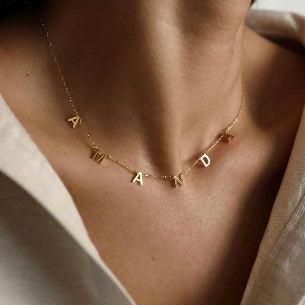 Personalized Name Necklace From Separate Letters showcasing elegant gold letters on a delicate chain worn around the neck.