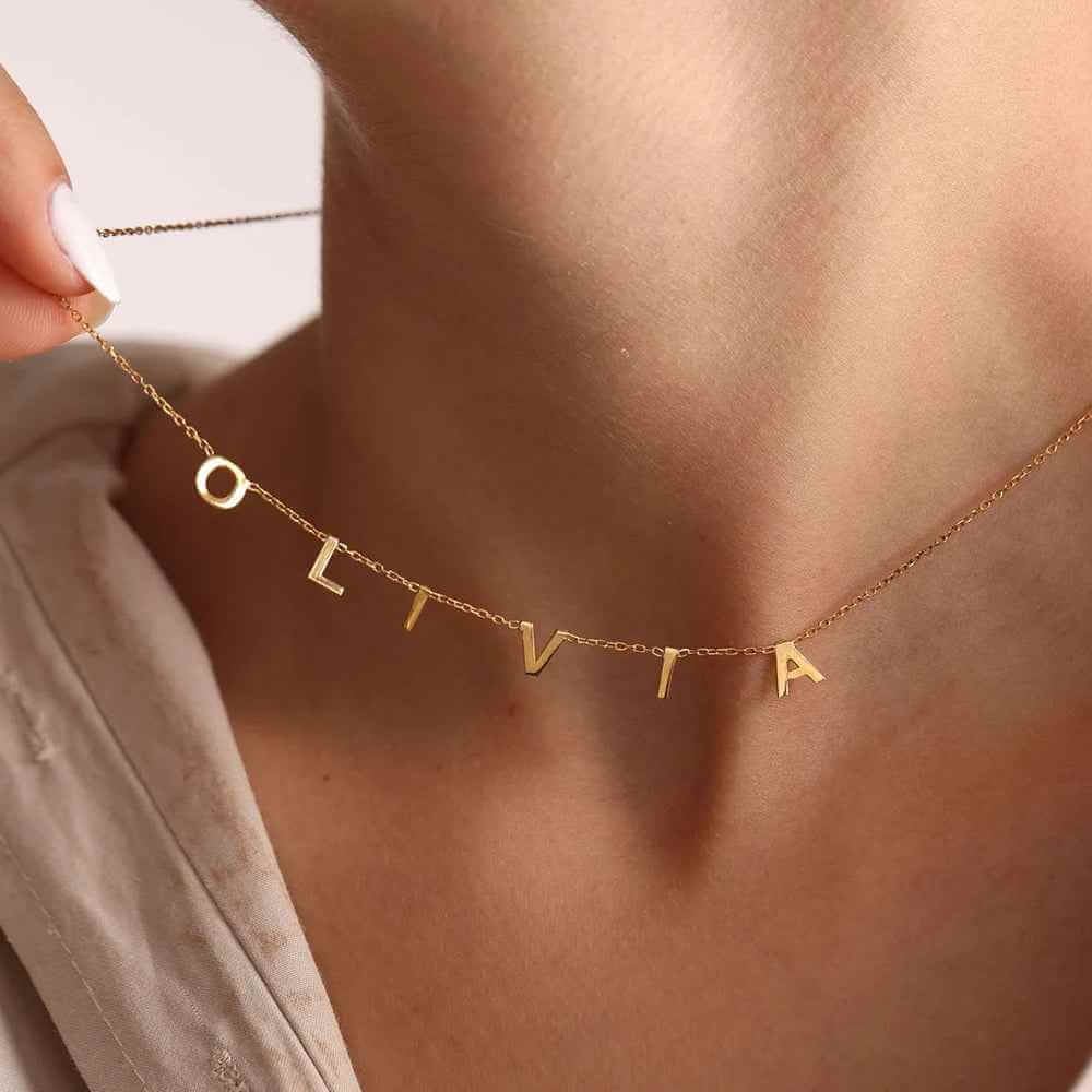 Personalized Name Necklace From Separate Letters showcasing elegant gold letters on a delicate chain worn around the neck.