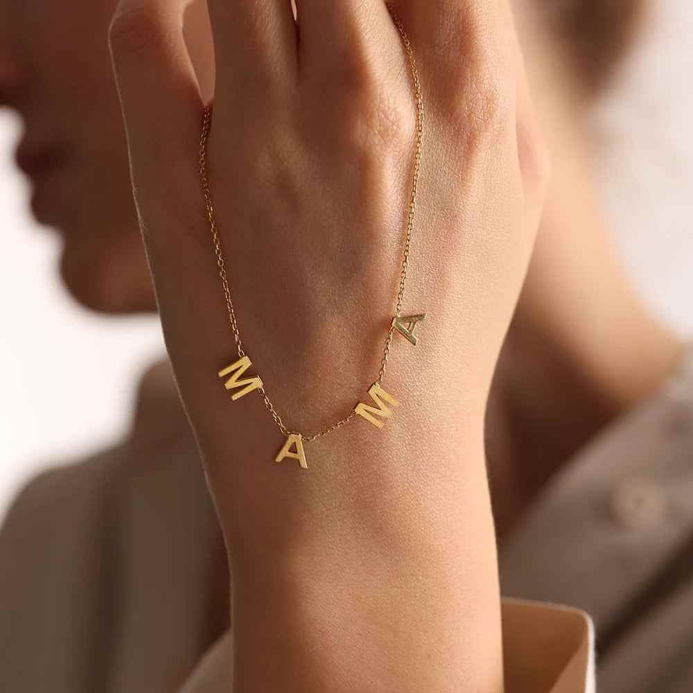 Personalized Name Necklace From Separate Letters showcasing elegant gold letters on a delicate chain worn around the neck.